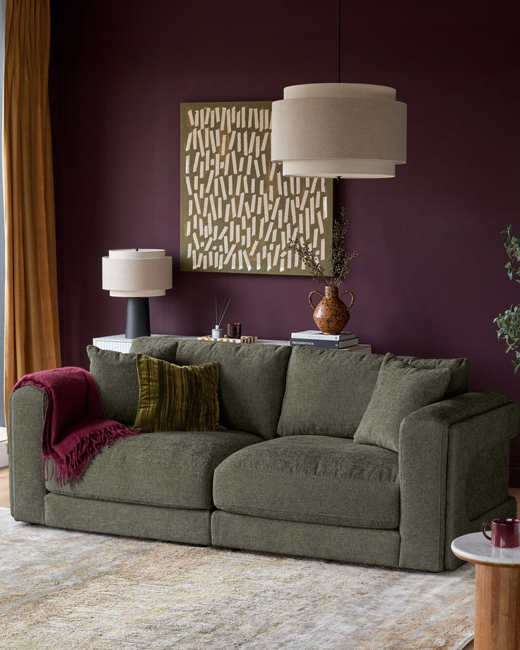 Lynetta 3-seater sofa in dark green weave fabric, displayed in a styled living room setting with cushions and a throw blanket.