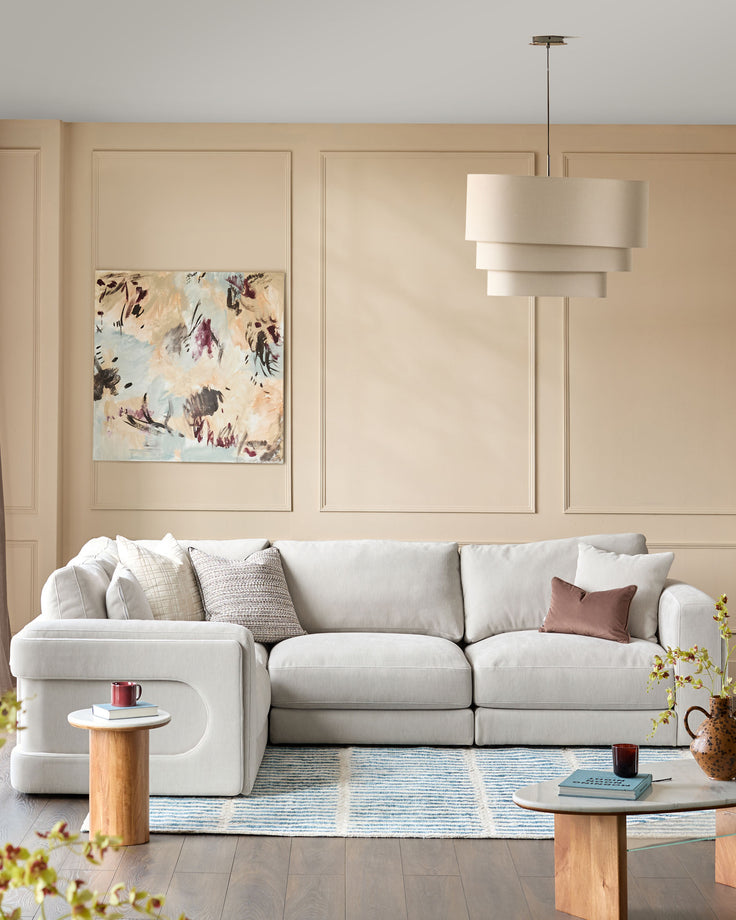 Lynetta small corner sofa in natural grey weave fabric, styled in a light, neutral living room setting.