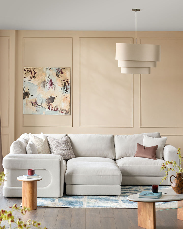 Lynetta small corner sofa with footstool in natural grey weave fabric, styled in a modern living room setting.
