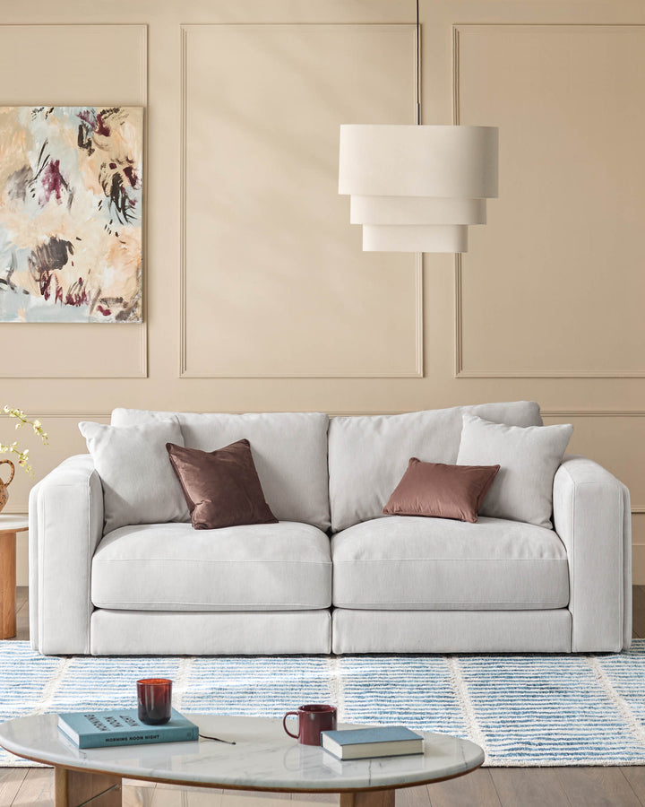 Lynetta 3-seater sofa in natural grey weave fabric, displayed in a modern living room setting with decorative pillows.