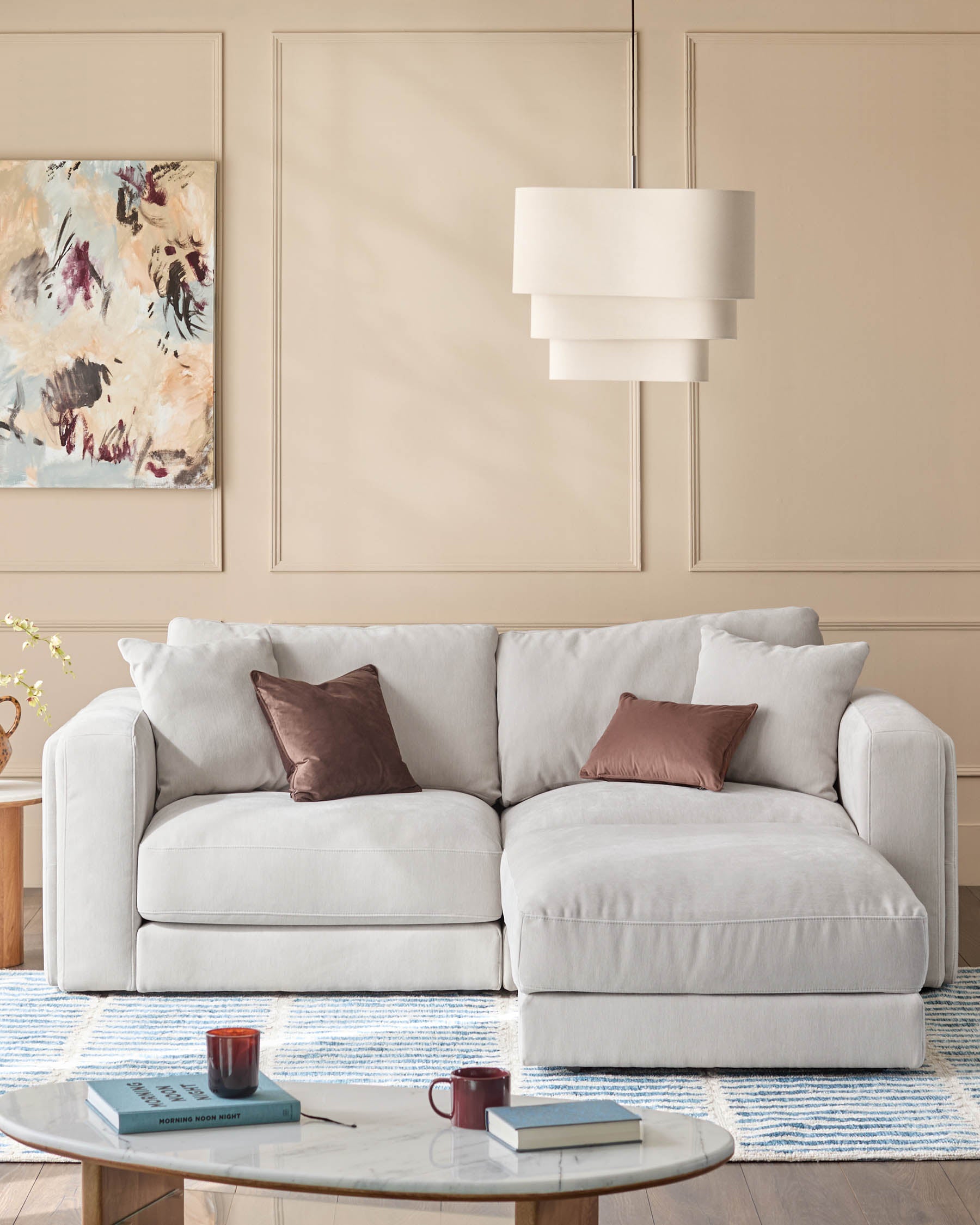 Lynetta 3-seater sofa with footstool in natural grey weave fabric, styled in a neutral living room with decorative pillows.