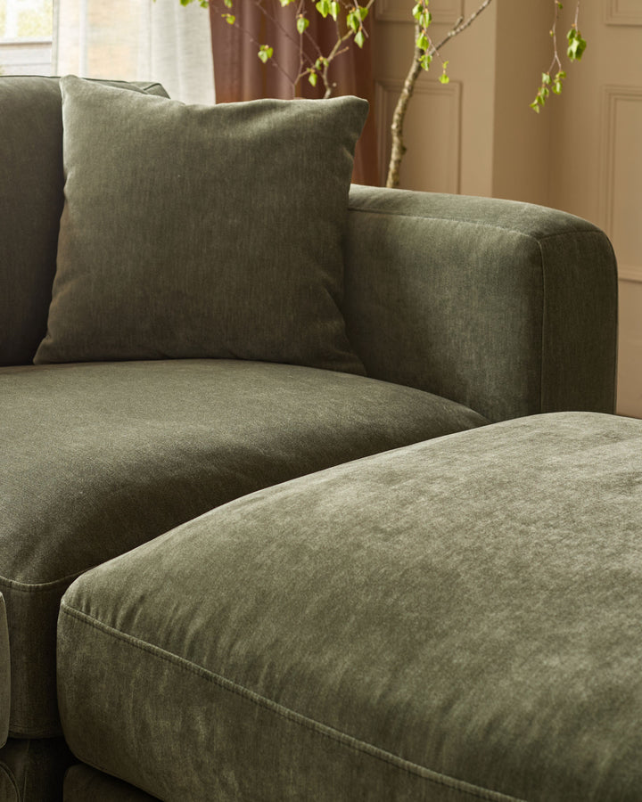 Lynetta 3-seater sofa with footstool in dark green weave fabric, close-up detail showing cushioned seat and back.