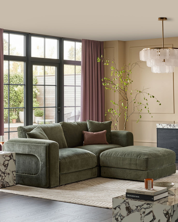 Lynetta 3-seater sofa with footstool in dark green weave fabric, displayed in a bright living room with large windows and contemporary décor.