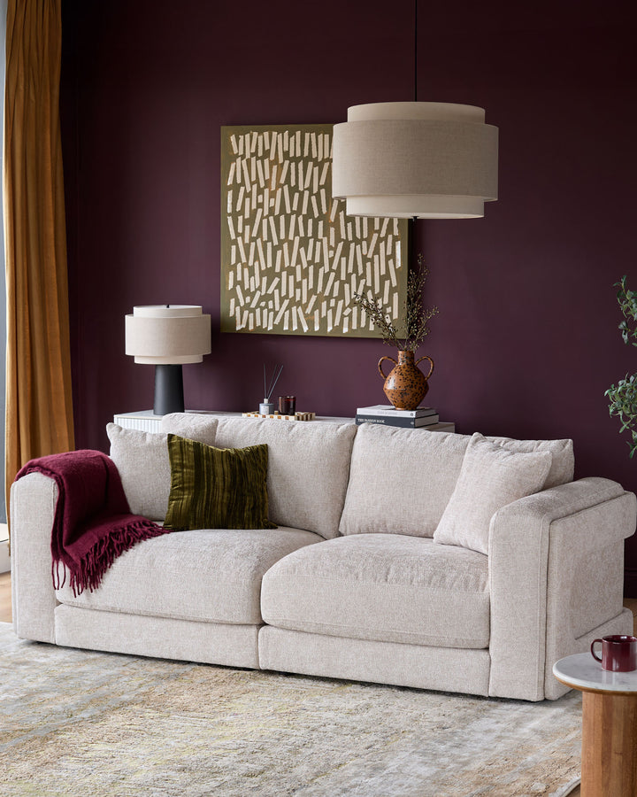 Lynetta 3-seater sofa in natural weave fabric, displayed in a styled living room setting with cushions and throw blanket.