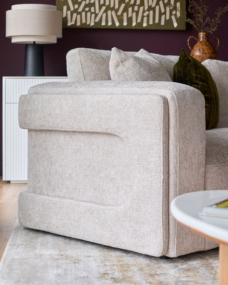 Lynetta 3-seater sofa in natural weave fabric, shown from side angle with rolled armrests and cushioned back.