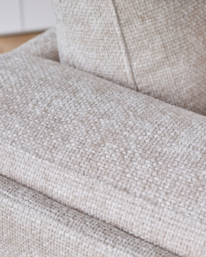 Close-up of natural weave fabric on Lynetta 3-seater sofa, showing textured beige upholstery and cushioned seat detail.