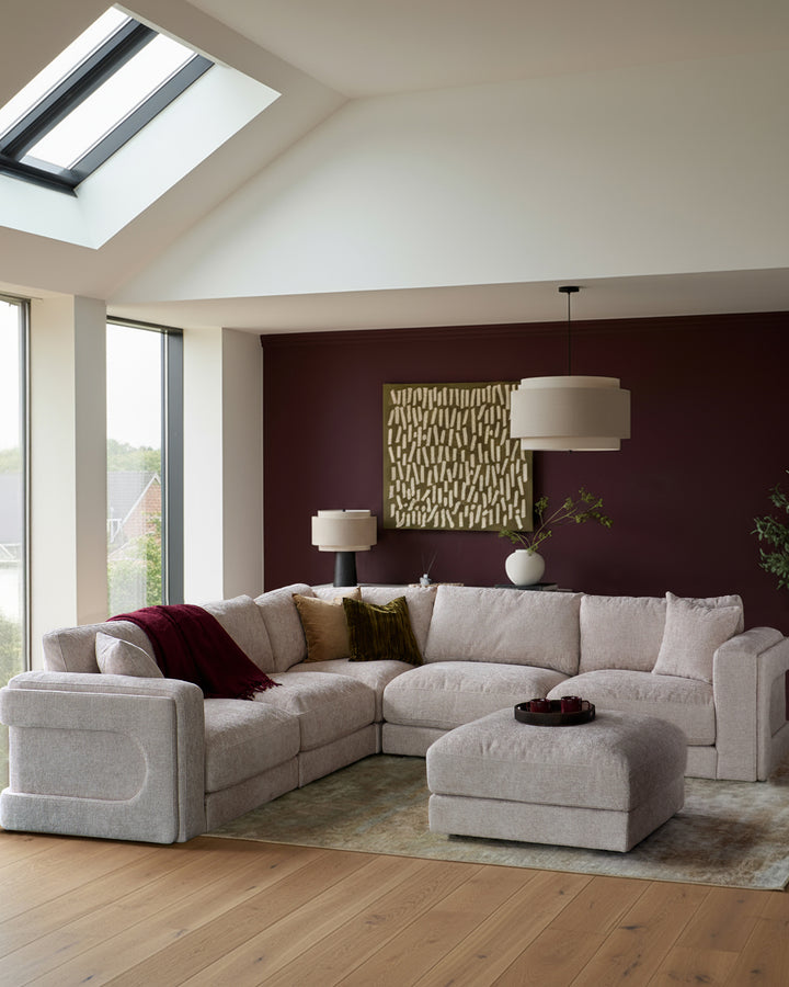 Lynetta single-module sofa in natural weave fabric, shown as part of a sectional arrangement in a modern living room.