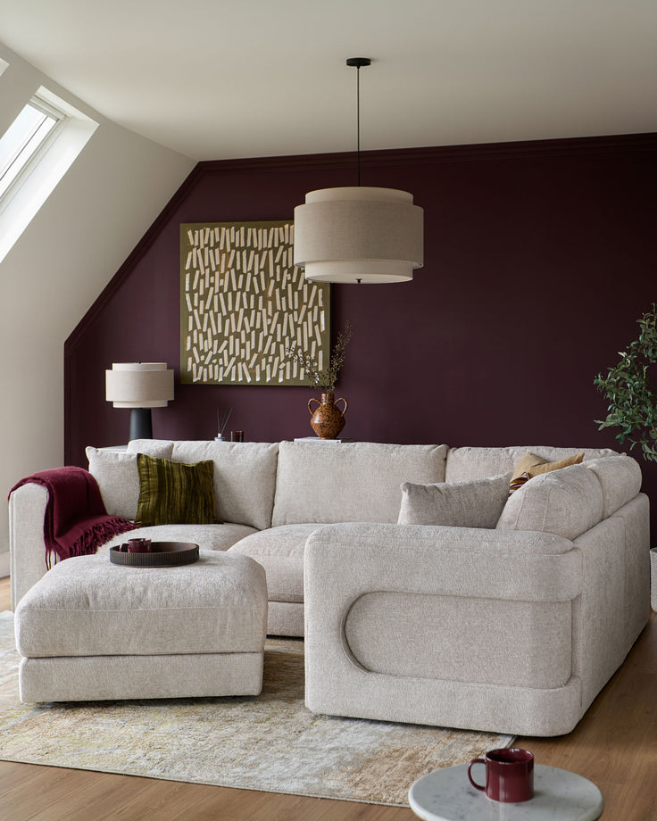 Lynetta small corner sofa with footstool in natural weave fabric, displayed in a styled living room setting.