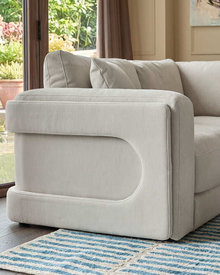 Lynetta 3-seater sofa with footstool in natural grey weave fabric, curved arm detail, positioned by garden doors.