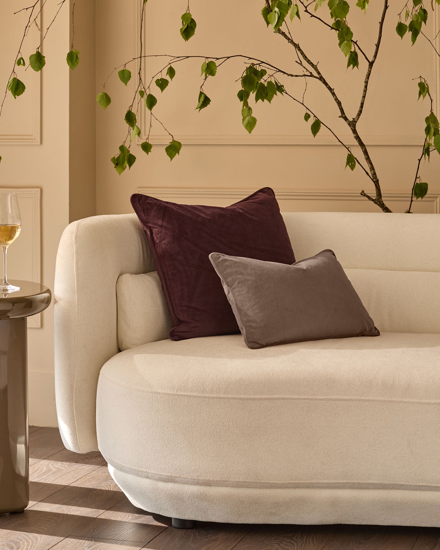 Mink rectangular cushion displayed on a cream curved sofa in a styled living room setting.