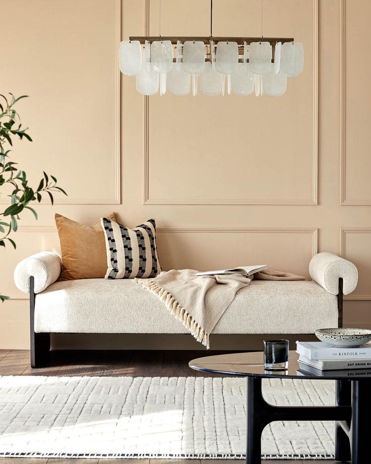 Stylish living room with modern sofa, coffee table, patterned rug, and lighting fixture.