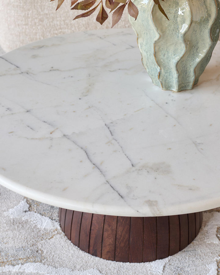 Malin coffee table with white marble top and dark mango wood base, round shape, styled with dried botanicals.