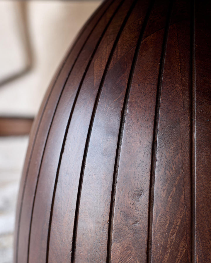 Close-up of dark mango wood base showing vertical fluting and rich brown finish with natural grain detail.
