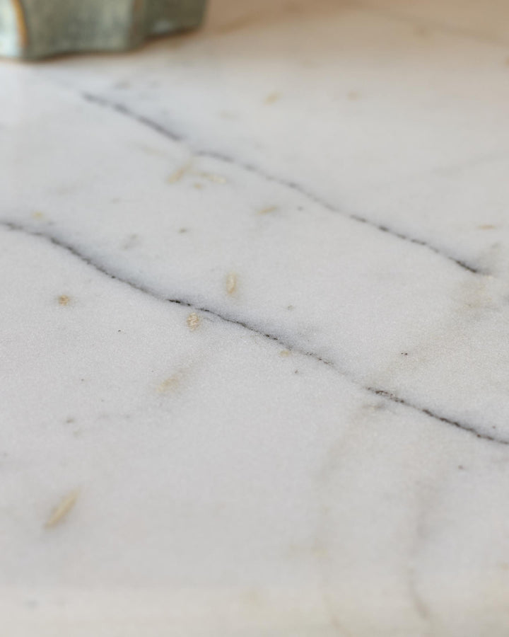 Close-up of white marble tabletop showing natural veining and texture detail on the Malin coffee table.