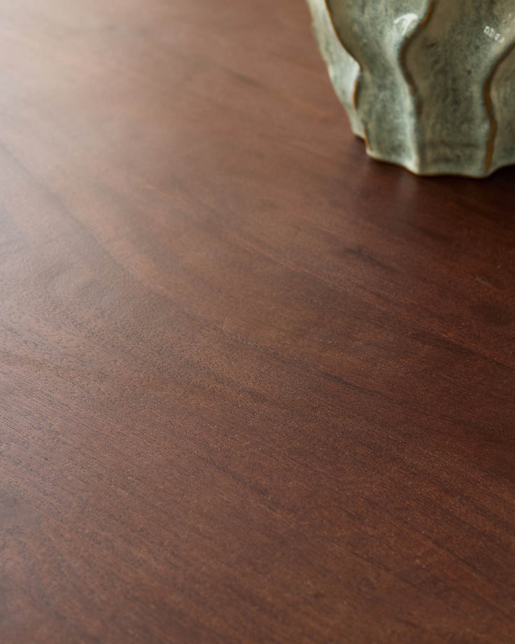 Close-up of dark mango wood table surface showing rich brown finish and wood grain texture with metal handle detail.
