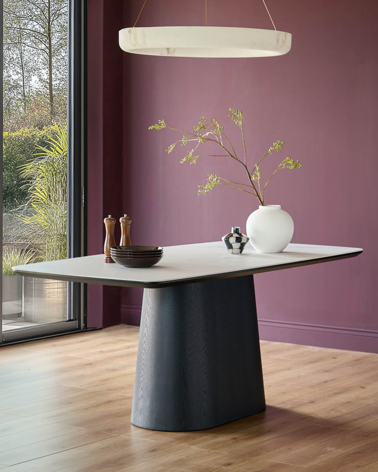 Manhattan 8-seater dining table with white ceramic top and dark wood pedestal base, shown in modern dining room setting.