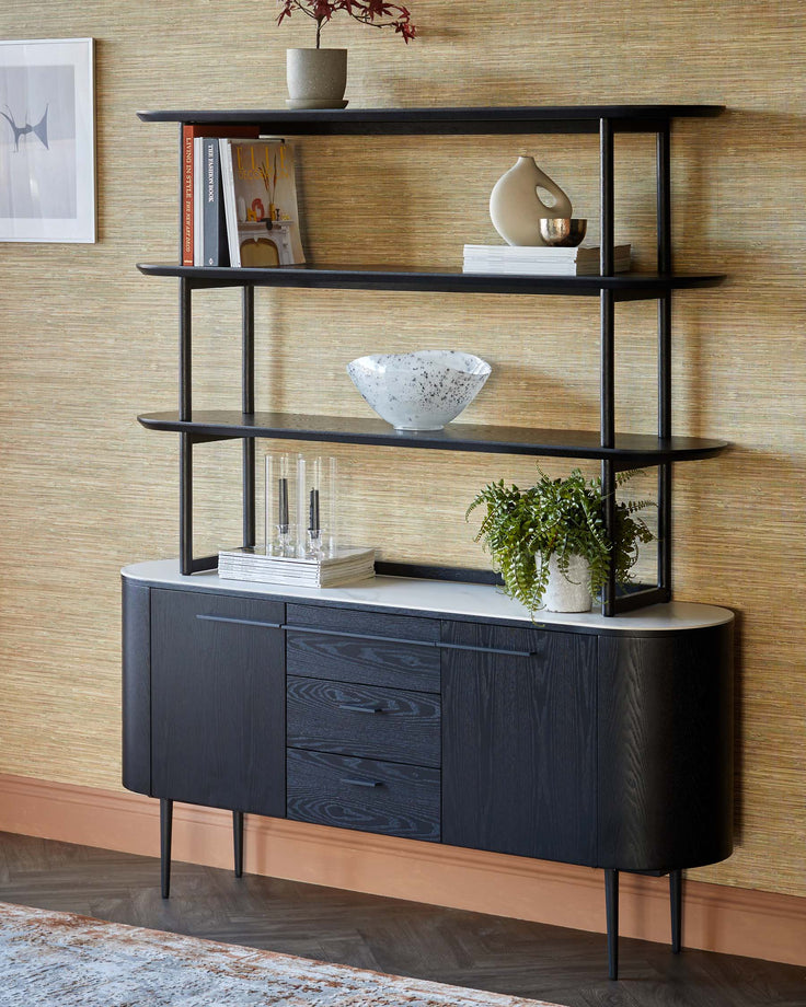 Black wooden sideboard with white marble top, curved front, three drawers, and matching wall shelving unit above.