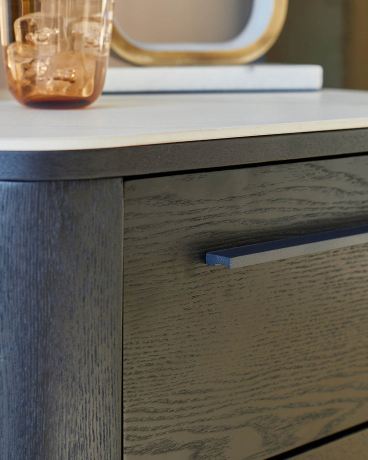 Dark wood bedside table with white ceramic top, featuring a drawer pull detail and minimalist design.