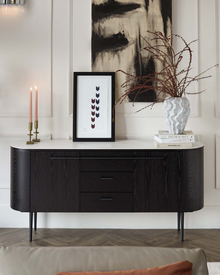 Elegant black sideboard with a curved design featuring distinct wood grain textures, supported by slender, tapered legs. Includes a combination of drawers and cabinet doors with discreet handles, complementing a sophisticated and modern interior space.