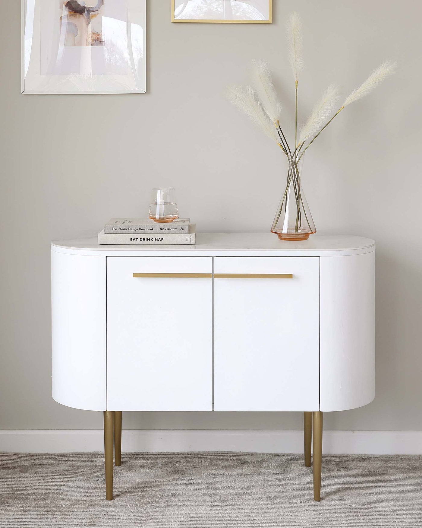 Elegant modern white curved sideboard with gold-coloured tapered metal legs and matching gold handles.