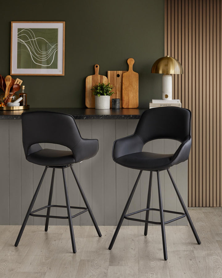 A pair of sleek black bar stools with a minimalist design provide seating at a counter.