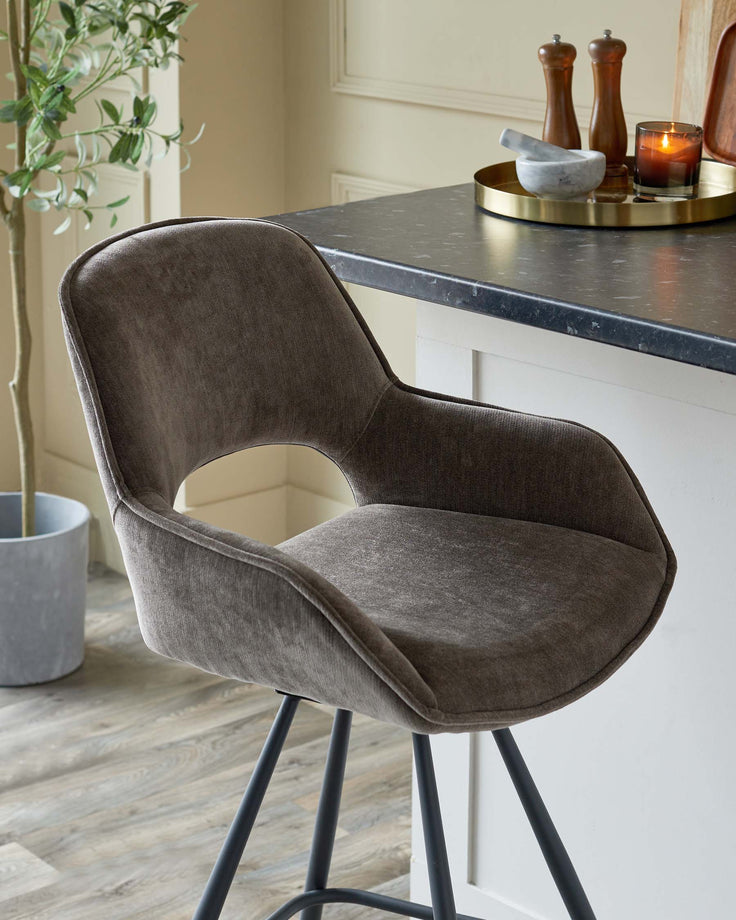 Stylish bar stool with grey upholstery and black metal legs. Perfect for adding a touch of modern elegance to any kitchen.