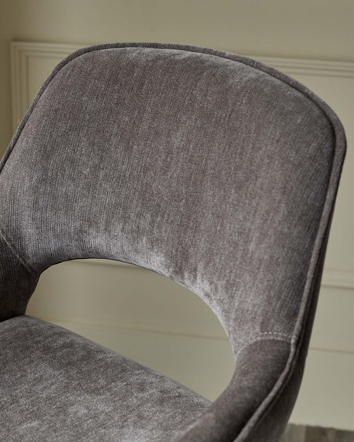 Close-up of a brown upholstered chair, showcasing its curved backrest and plush fabric.