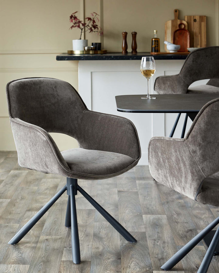 Modern dining area with brown, bucket-style chairs and a sleek, dark table with a glass of white wine.