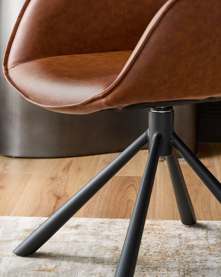 Tan leather swivel dining armchair with curved backrest and black metal tripod base, angled view.