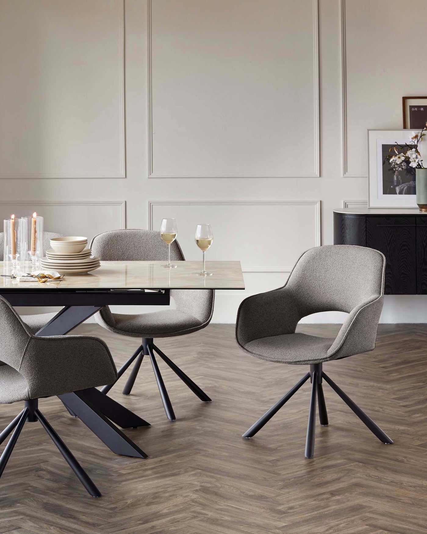 Modern dining room furniture featuring a rectangular table with a light marble top and angular black metal legs, paired with four upholstered mid-century modern-inspired chairs with curved backs and black metal base.
