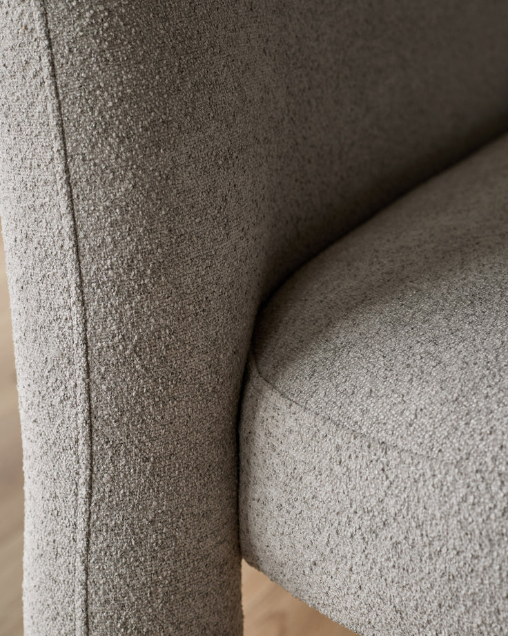 Mason 3-seater dining bench in light grey boucle, close-up of curved armrest and seam detail.