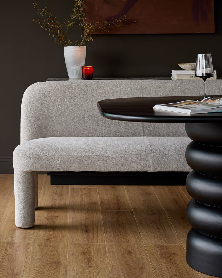 Mason 3-seater dining bench in light grey boucle, showcasing curved back and sides, positioned in modern interior setting.