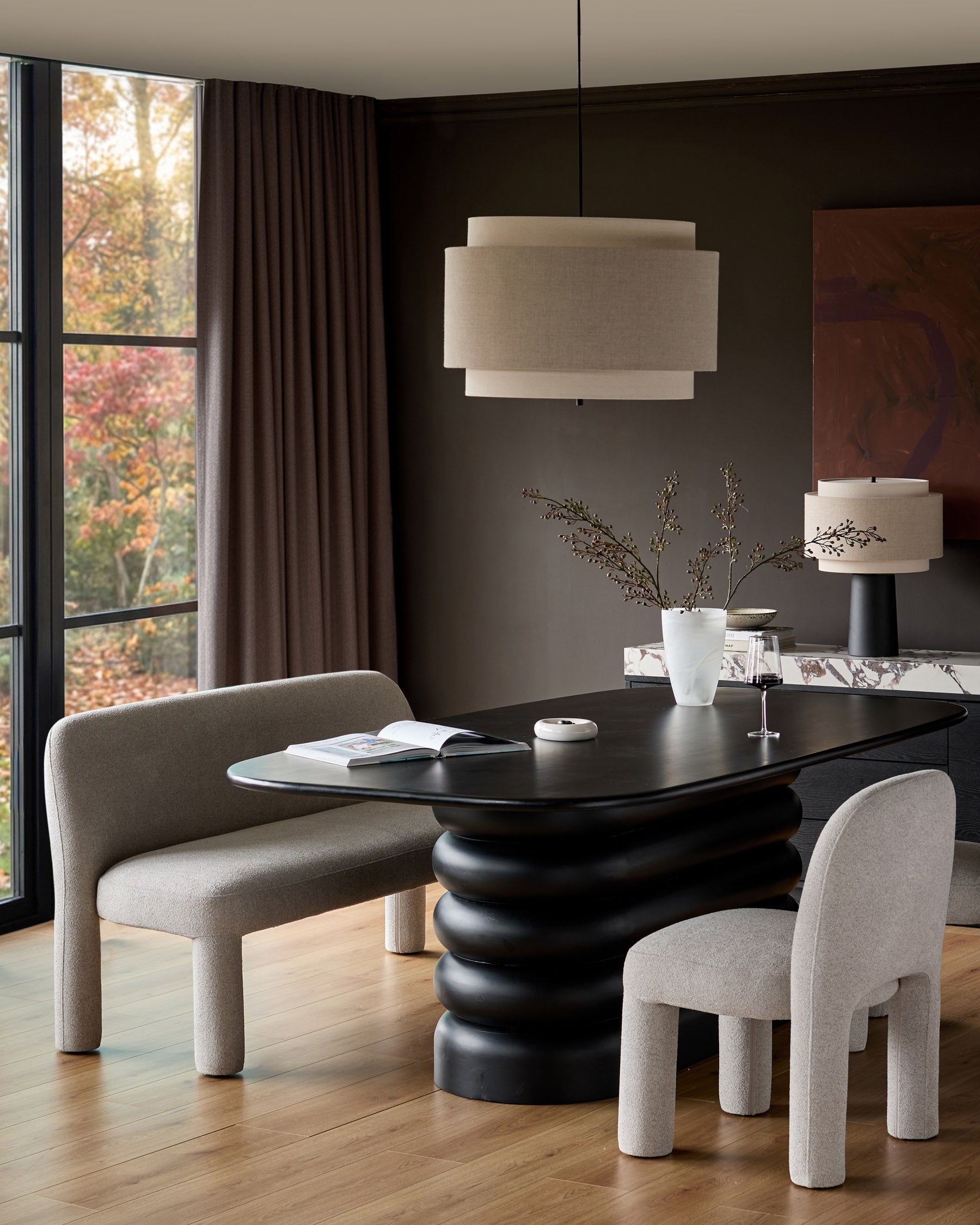 Mason dining chair in light grey boucle, shown in modern dining room setting with black table and pendant lighting.