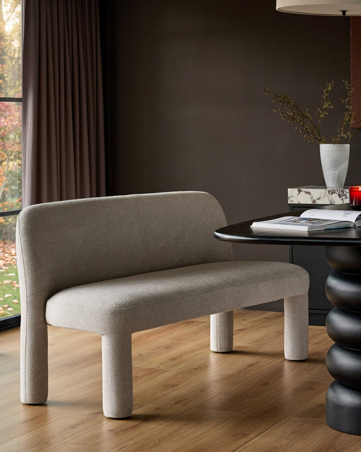 Mason 3-seater dining bench in light grey boucle, shown in a modern room setting with rounded legs and curved backrest.