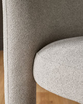 Mason dining chair in light grey boucle, close-up of curved backrest and seat detail.