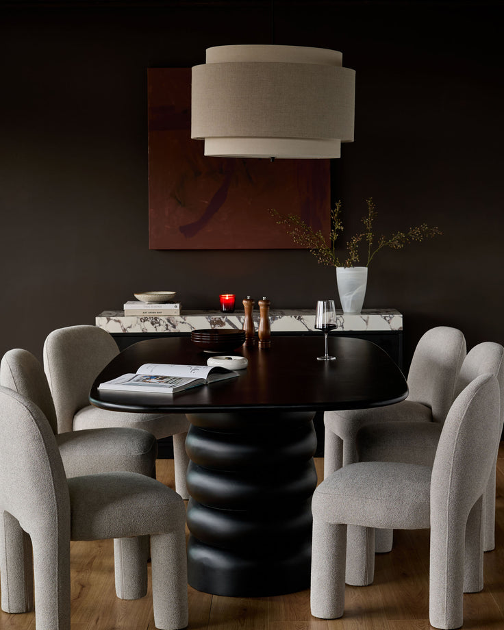 Mason Dining Chair in light grey boucle, shown in a styled dining setting around a black round table.