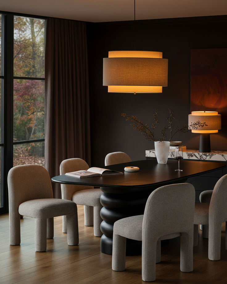 Mason dining chair in light grey boucle, shown in a styled dining room setting around a black table.
