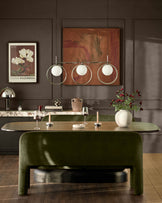 Mason 3-seater dining bench in olive green velvet with curved design, shown in styled dining room setting.
