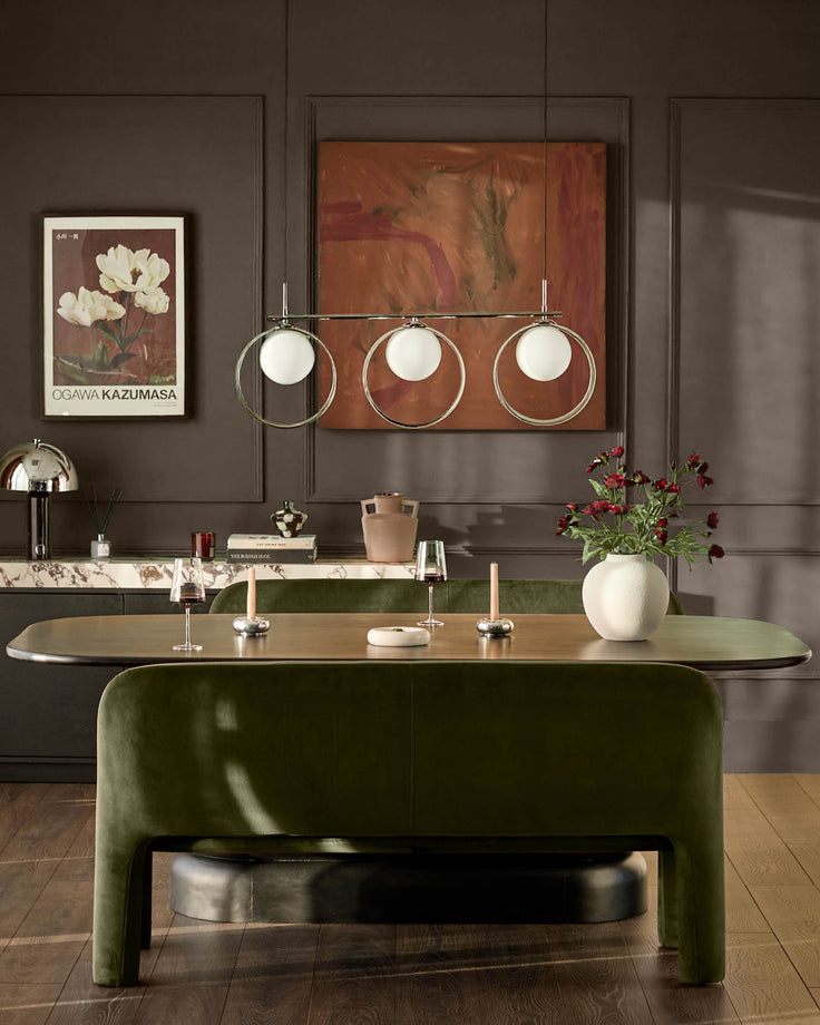 Mason 3-seater dining bench in olive green velvet with curved design, shown in styled dining room setting.