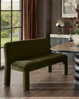Mason 3-seater dining bench in olive green velvet with rounded cylindrical legs, displayed in a modern dining room setting.
