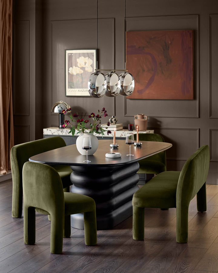 Mason 3-seater dining bench in olive green velvet, shown in modern dining room setting with black sculptural table.