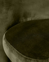 Mason dining chair in olive green velvet, close-up of curved seat and piping detail.