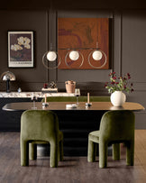 Mason dining chair in olive green velvet, rounded cylindrical back and seat, viewed in modern dining room setting.