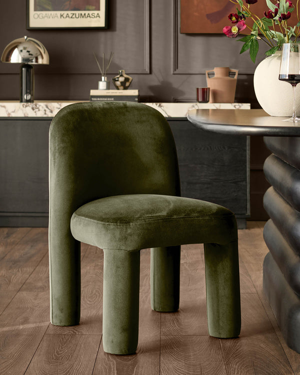 Mason dining chair in olive green velvet with curved cylindrical legs, shown in modern room setting.