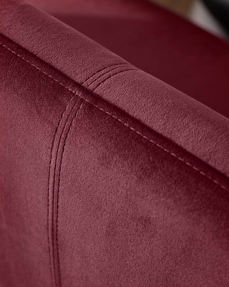 Plum velvet dining bench showing close-up of stitched seam detail and soft fabric texture.