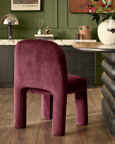 Mason dining chair in plum velvet, shown in a modern interior setting at a curved desk.