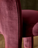 Mason dining chair in plum velvet, close-up detail of seam and upholstery texture with wooden leg visible.