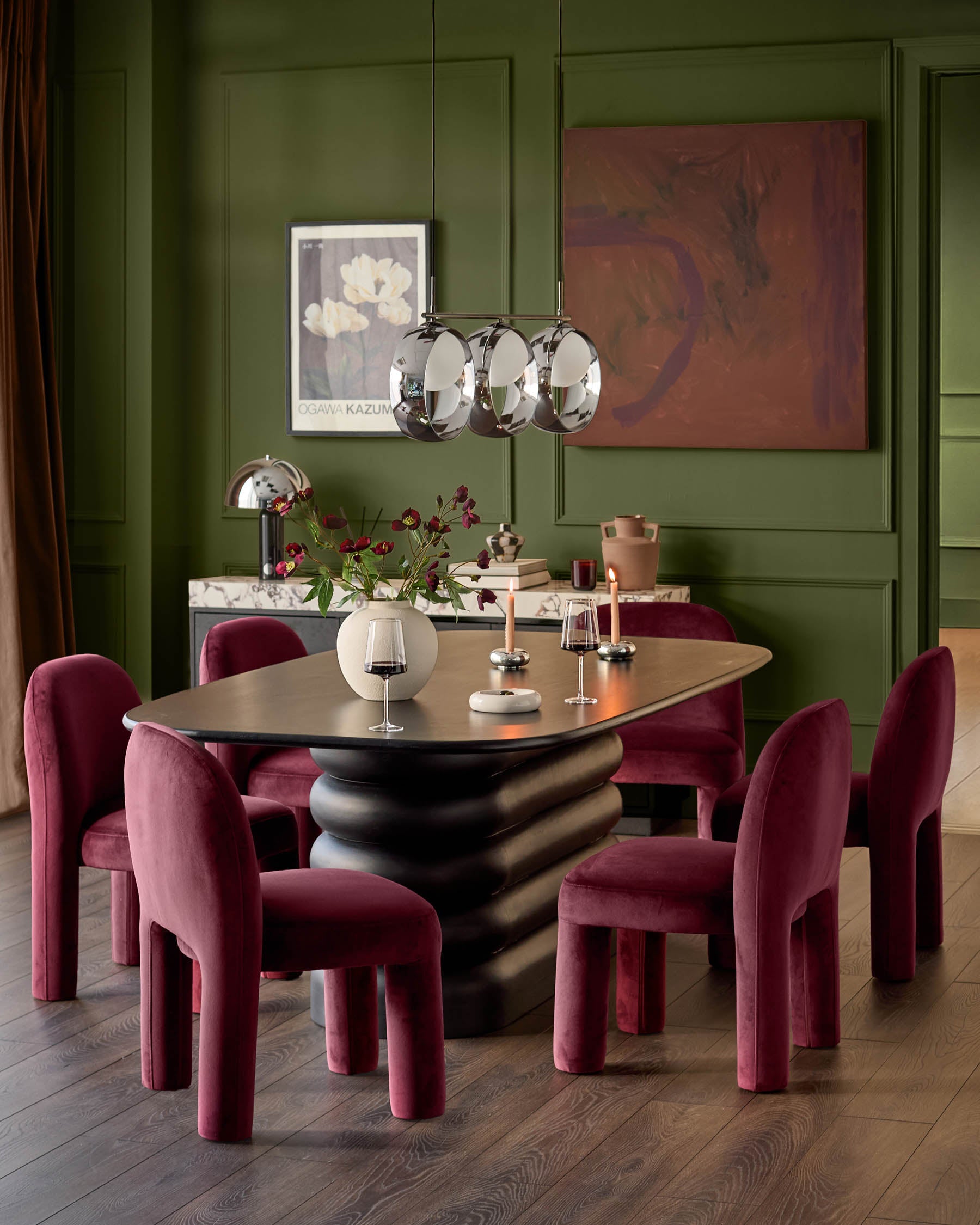 Mason dining chair in plum velvet, shown in a dining setting with four chairs around a sculptural black table.