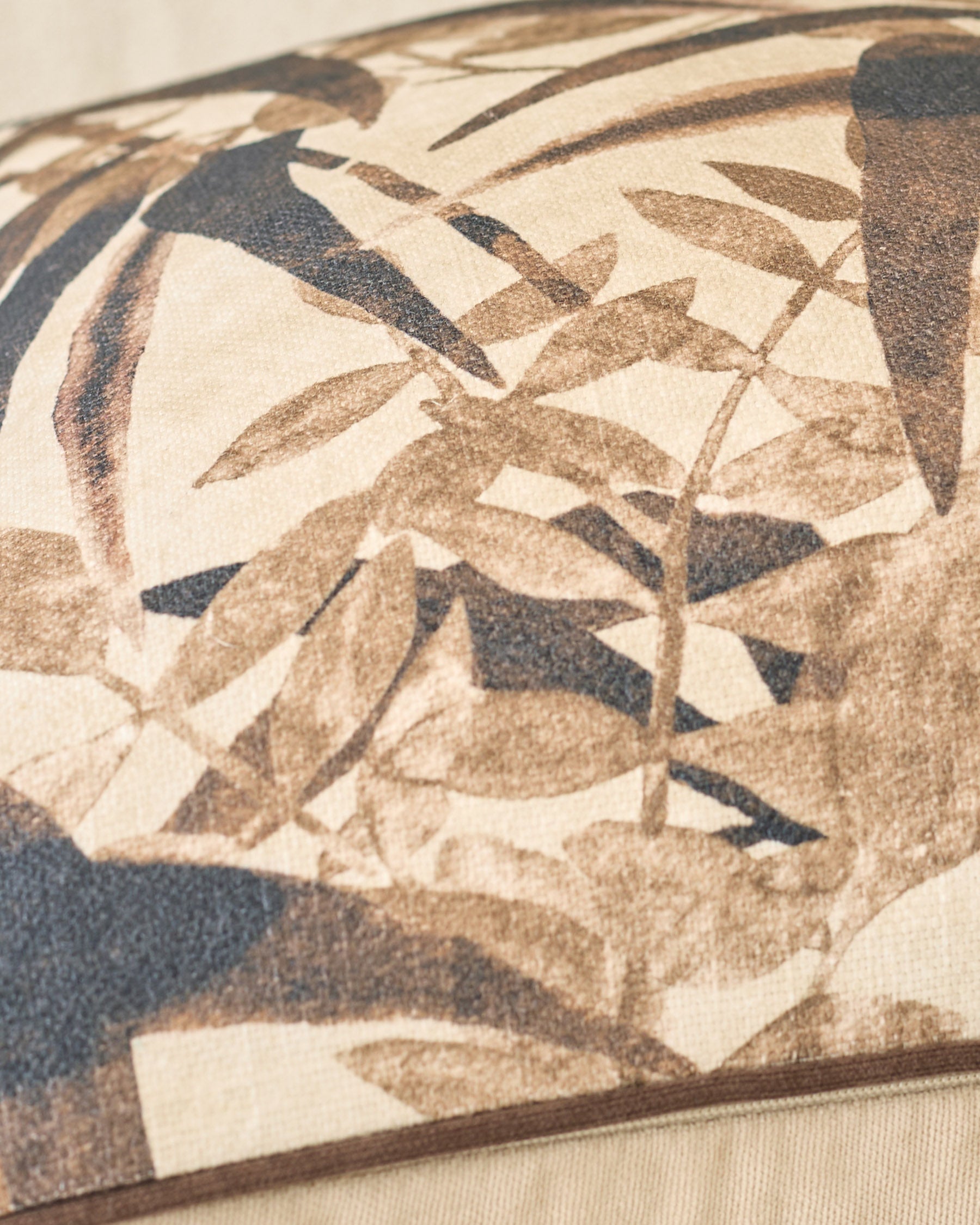 Madeira cushion in natural tones featuring botanical leaf pattern in cream, tan, and charcoal.