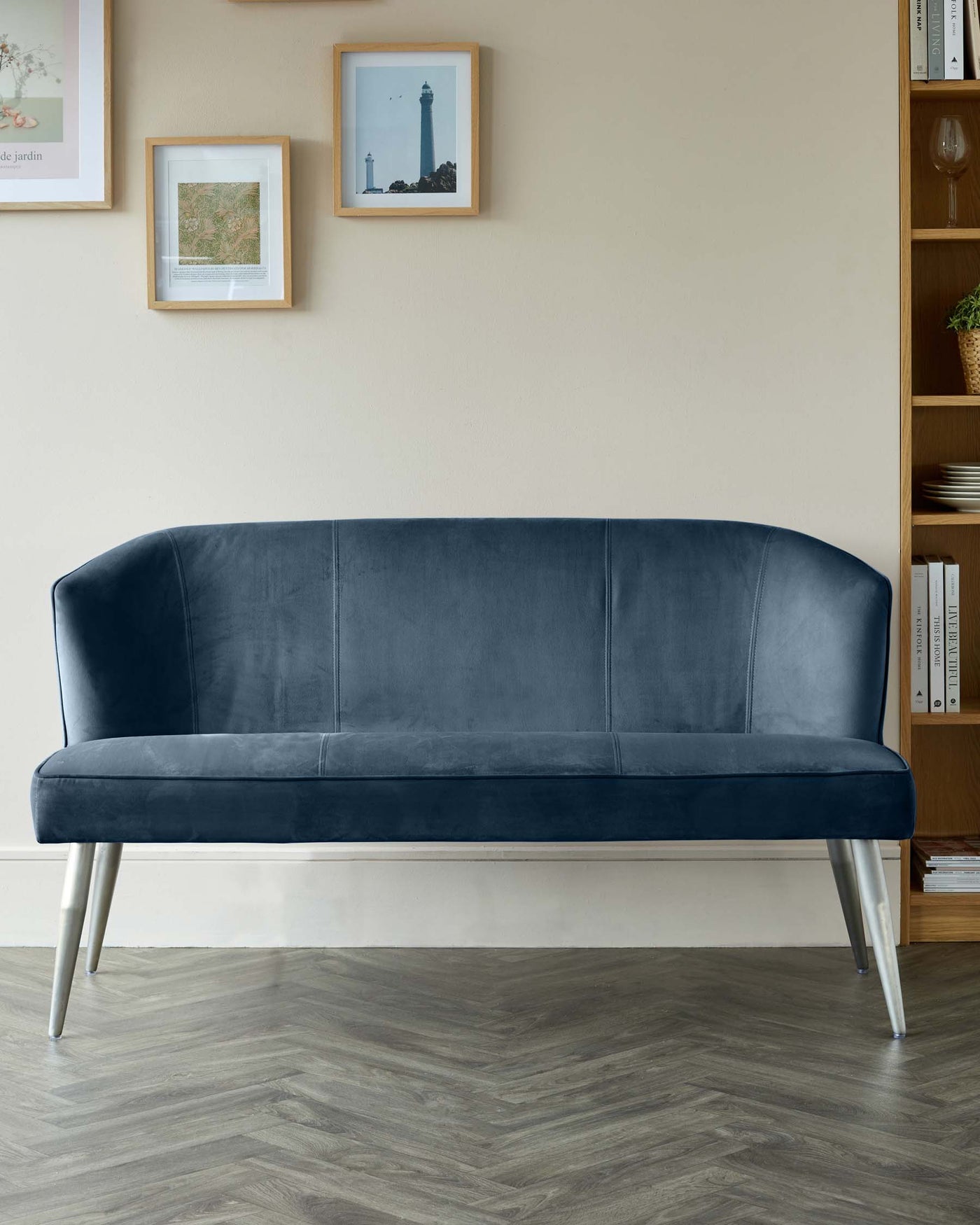 Elegant contemporary velvet sofa with a curvilinear silhouette, tufted backrest, and slanted metal legs.